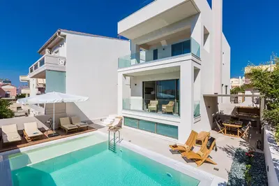a villa with a swimming pool and a house at Villa Amelia I Free 8 seater mini van & pool in Kalathas
