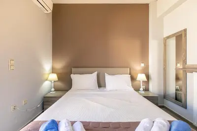 a bedroom with a bed with two lamps and two pairs of shoes at Villa Neaira in Vatólakkos