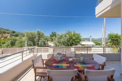 a table and chairs on the balcony of a house at Villa Neaira in Vatólakkos