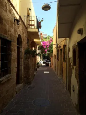 an alley in an old town with pink flowers at Katerina Traditional Rooms in Chania Town