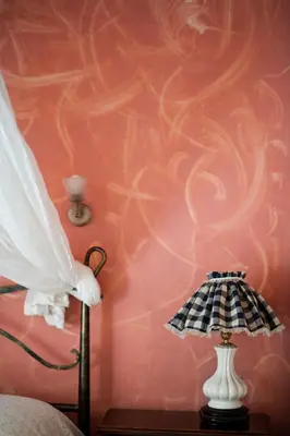 a bedroom with a pink wall with a lamp at Katerina Traditional Rooms in Chania Town