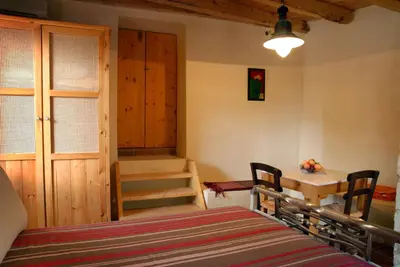 a bedroom with a bed and a table and stairs at Villa Irini - Authentic Cretan Retreat with Private Pool in Vafés
