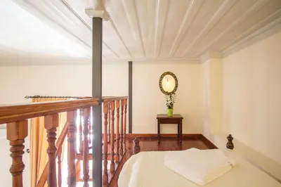 a room with a bed and a mirror on a balcony at Vilelmine in Chania Town