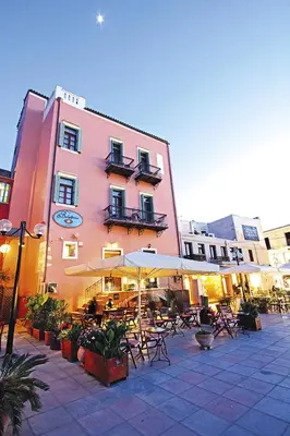 a building with tables and umbrellas in a courtyard at Vilelmine in Chania Town