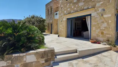 a stone building with a door and a patio at Thealia in Karefilianá