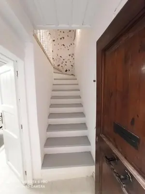a staircase leading up to a room with white walls at Casa Topane in Chania Town