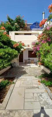 a walkway in front of a building with flowers at Doma Apartments in Falasarna