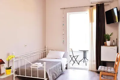 a bedroom with a bed and a sliding glass door at Rooms Kochilas Elafonisi in Elafonisi