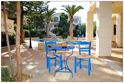 a blue table and chairs next to a pool at Kastalia Village ,Saint Nikolas resort in Kolymvari