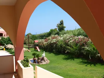 a view of a garden from an archway at Villa Rita Apartments A in Tavronitis