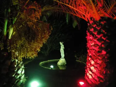 a fountain with a statue in a garden at night at Villa Rita Apartments A in Tavronitis