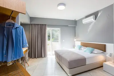 a bedroom with a bed with a blue wall at Villa Aelia I Modern & Ideal for large groups in Galatás