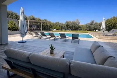 a large couch sitting on a patio next to a pool at Villa Aelia I Modern & Ideal for large groups in Galatás