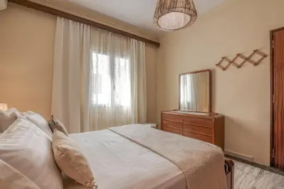 a bedroom with a bed and a dresser and a window at Kalliopi's Maisonette in Chania Town
