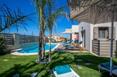 a villa with a swimming pool and palm trees at SUPERIOR VILLA MARINA MARE Sauna - Hammam - Pool - 250m from Beach in Agia Marina Nea Kydonias
