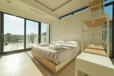 a bedroom with a bed and a large window at Villa L2/ Boutique Villa in Kato Daratso