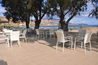 a group of tables and chairs on a patio at Nautilus Bay Hotel in Kissamos