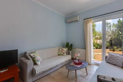 a living room with a couch and a tv at Villa Armonia Chania in Kato Galatas