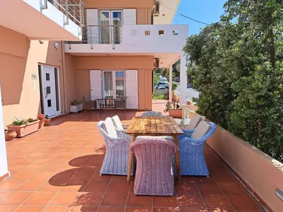 a patio with a wooden table and chairs at Villa Armonia Chania in Kato Galatas