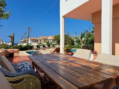 a wooden table and chairs on a patio at Villa Armonia Chania in Kato Galatas