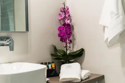 a bathroom with a sink and a purple orchid at The48suites in Chania Town