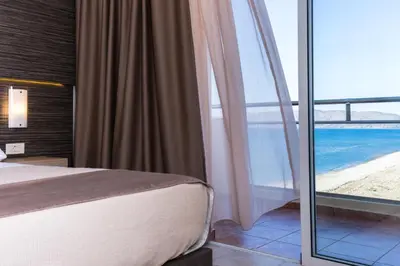 a bedroom with a bed and a view of the ocean at Sunny Bay Hotel in Kissamos