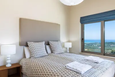 a bedroom with a bed with two pillows and a window at Angel Hill Villa in Xirokámbion