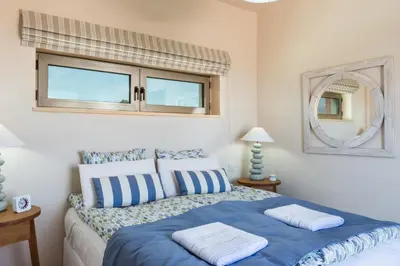 a bedroom with a blue bed and a mirror at Angel Hill Villa in Xirokámbion