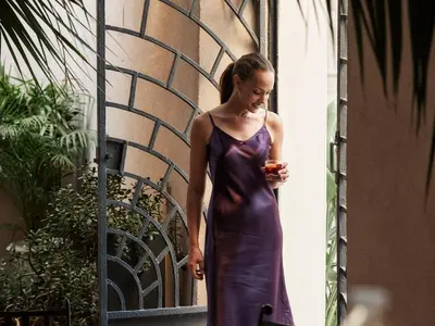 a woman in a purple dress walking down a street at Casa Delfino Hotel & Spa in Chania Town