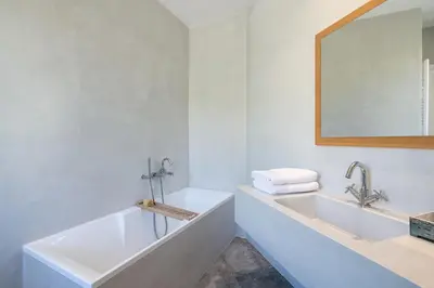 a white bathroom with a sink and a mirror at Casa le Cicale in Falasarna