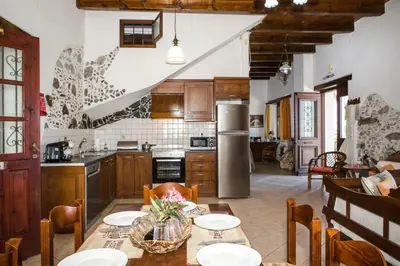 a kitchen with a table and chairs and a kitchen with a refrigerator at Pericles Beach Villa in Kissamos