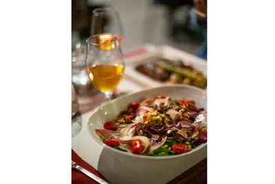 a bowl of salad on a table with a glass of wine at Villa Giannis in Áyios Andónios