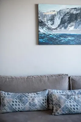 a couch with pillows sitting under a painting on a wall at Magia Apartments in Chania Town