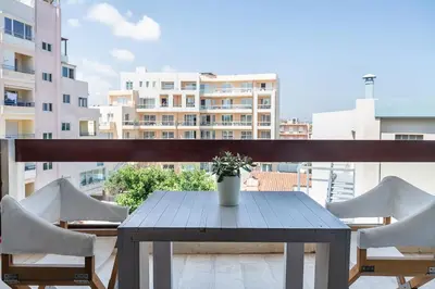 a table and chairs on a balcony with a building at Magia Apartments in Chania Town