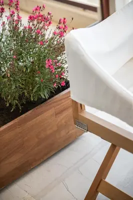 a white chair sitting next to some pink flowers at Magia Apartments in Chania Town