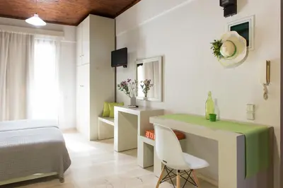 a bedroom with a bed and a table and a chair at Magia Apartments in Chania Town