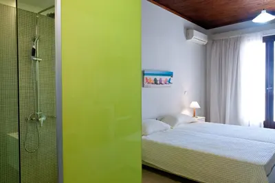 a bedroom with a bed and a glass shower at Magia Apartments in Chania Town