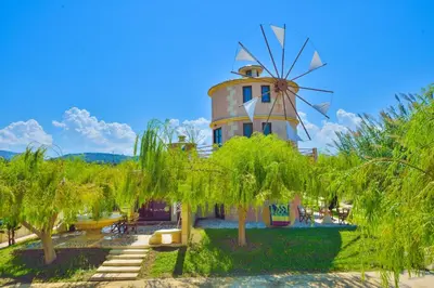 a windmill in a park with trees at Anemomili Village in Kissamos