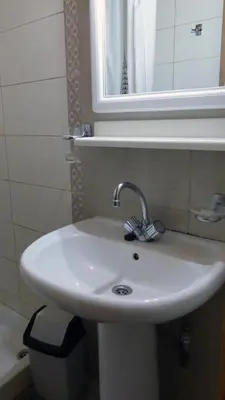 a white sink in a bathroom with a mirror at Kydonia Rooms in Chania Town