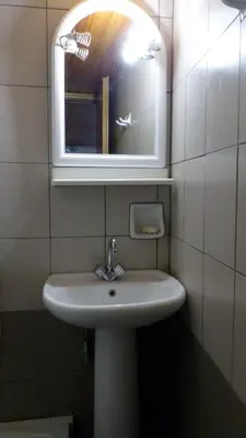 a bathroom with a white sink and a mirror at Kydonia Rooms in Chania Town