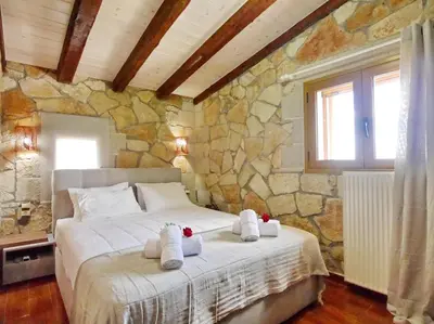 a bedroom with a large bed in a stone wall at Villa Vangelis Stylos Crete in Khiliomoudhoú