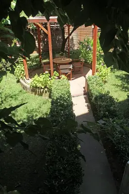 a garden with a table and a chair in the grass at Gardens Downtown center Chania Elpida Villa in Chania Town