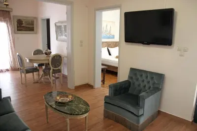 a living room with a couch and a tv on a wall at Gardens Downtown center Chania Elpida Villa in Chania Town