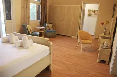 a bedroom with a bed and a living room at Gardens Downtown center Chania Elpida Villa in Chania Town