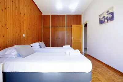 a bedroom with two beds and a wooden wall at Sunhouse-CH in Chania Town