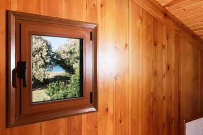 a wooden wall with a window in a room at Wooden Beach House in Gerani Chanion