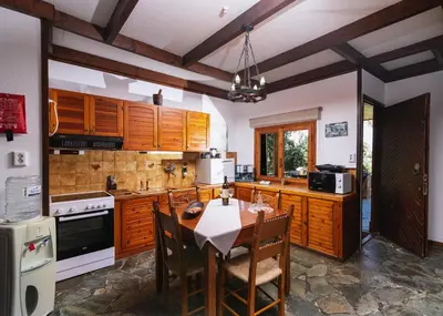 a kitchen with wooden cabinets and a table with chairs at Wooden Beach House in Gerani Chanion