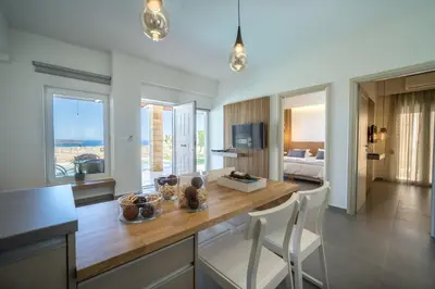 a kitchen with a table and chairs and a living room at Lofos Village Chania in Agia Marina Nea Kydonias