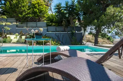 a chair and a table next to a swimming pool at Artistic Pool Private Villa in Chania Town