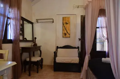a bedroom with a bed and a chair and a table at Odos Oneiron Boutique Hotel in Chania Town